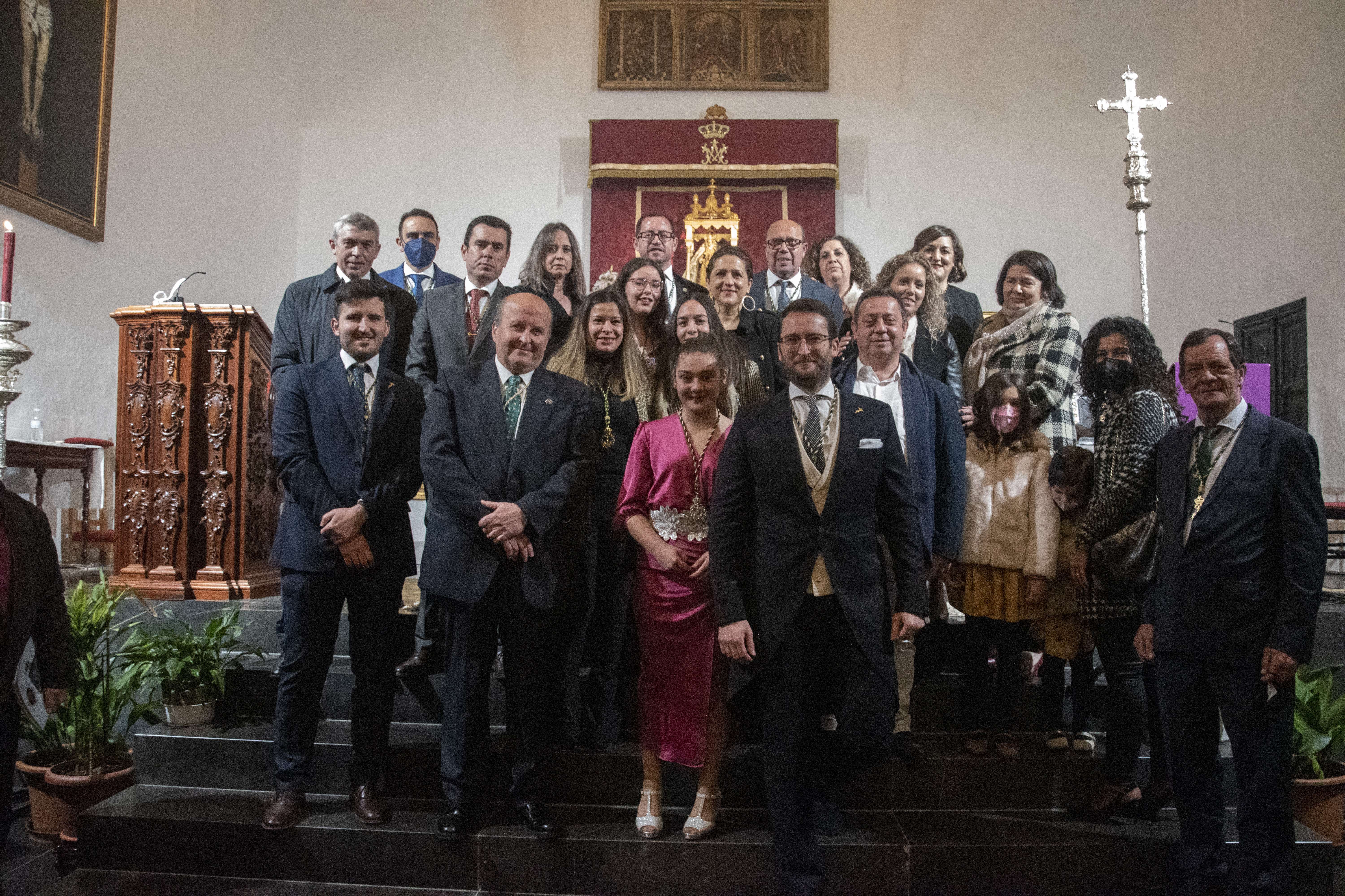 Los pregoneros de 2022, Juan Luque y Teresa Guerra, posan con la Junta Directiva y algunos familiares en el altar. Foto. ANGEL MEDINA
